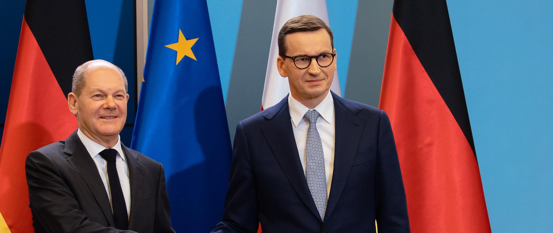 Premier Mateusz Morawiecki i kanclerz RFN Olaf Scholz na tle flag