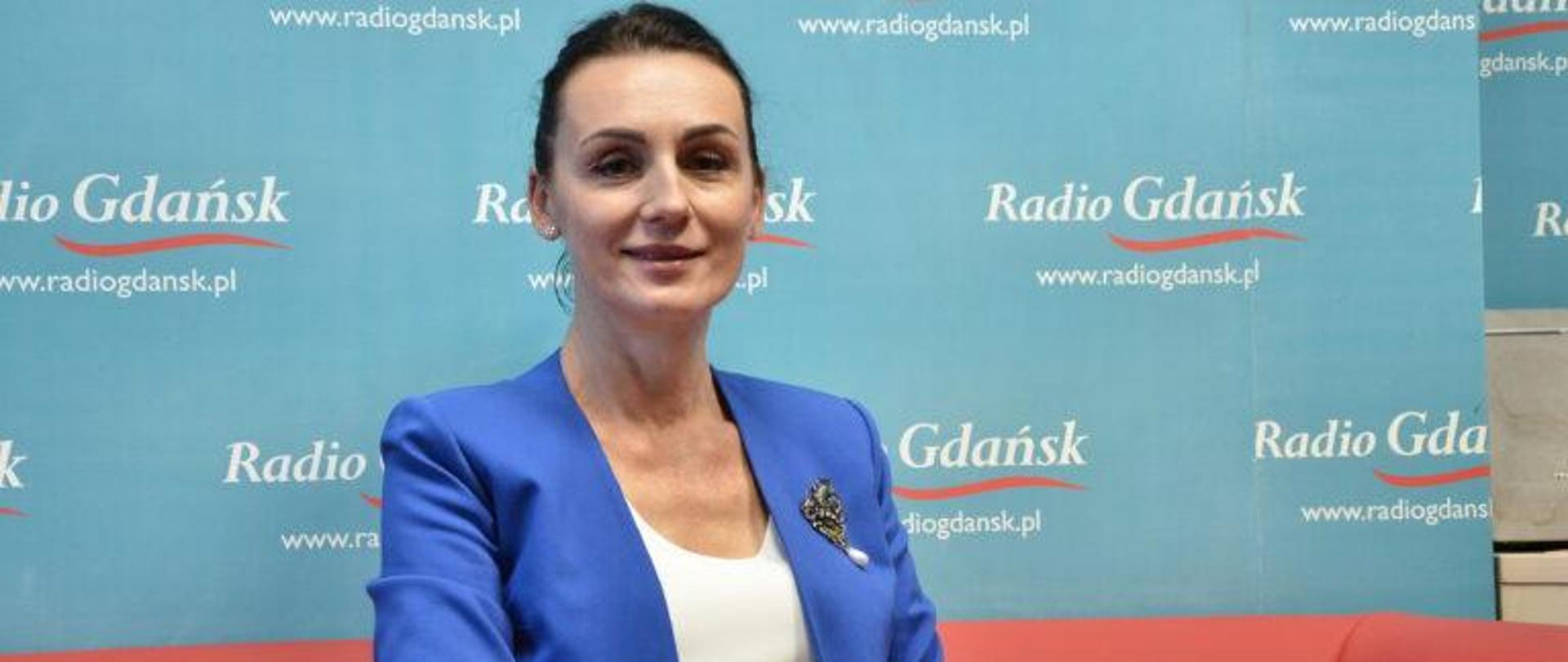 Kobieta (wojewoda) siedzi w studiu radiowym, w tle napis radio gdanisk