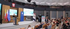 Przed mównicą pani prowadząca konferencję