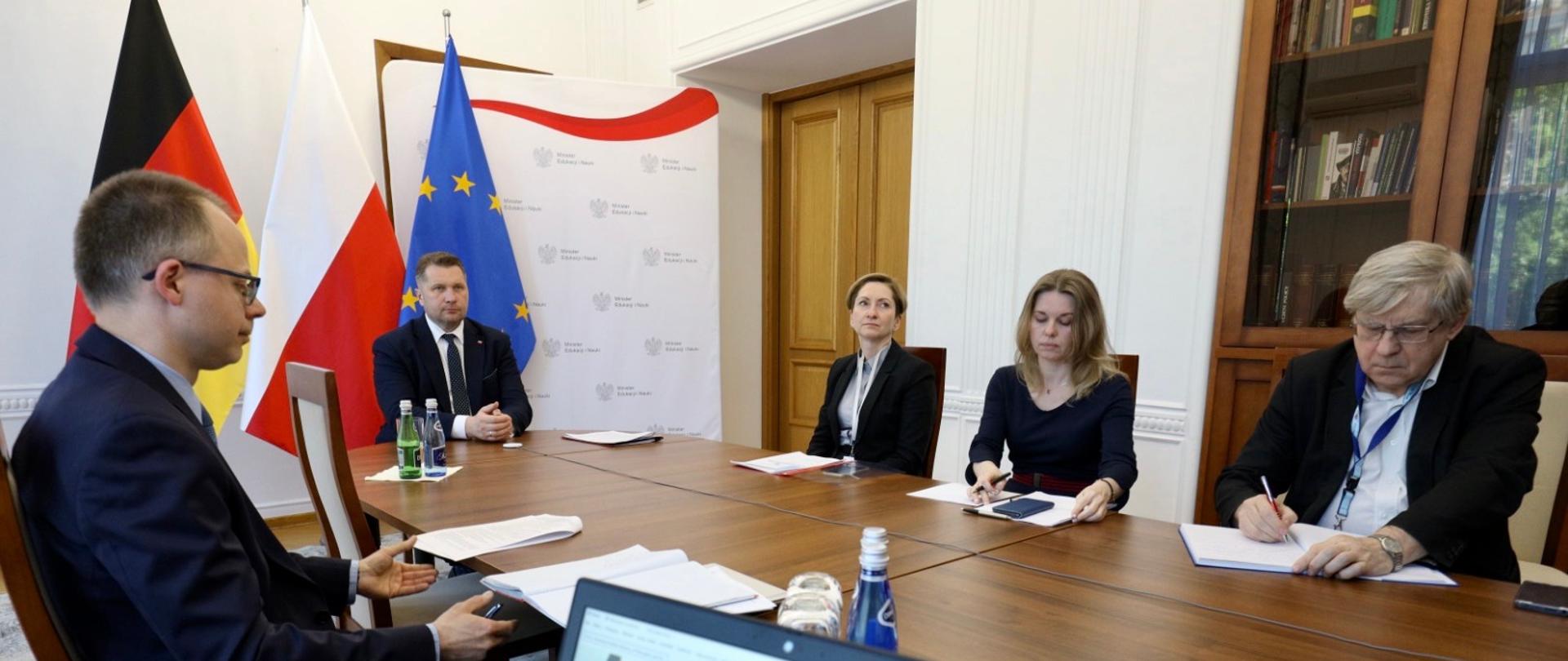 spotkanie przeprowadzane w formie online, minister Czarnek siedzi przy stole i rozmawia przez kamerkę