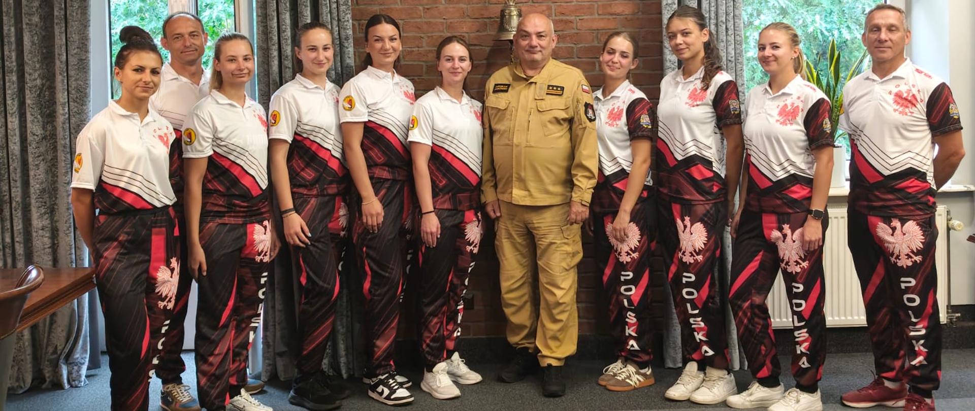 Gabinet Komendanta Centralnej Szkoły PSP, Komendant na pamiątkowym zdjęciu grupowym w towarzystwie zawodniczek oraz sztabu trenerskiego reprezentacji kobiet Centralnej Szkoły PSP w sporcie pożarniczym