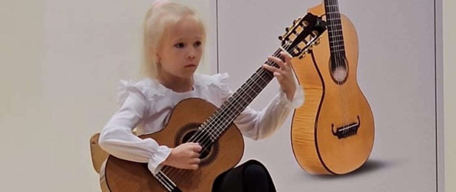 Uczennica Zuzanna Stach na scenie z gitarą