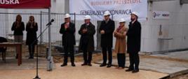 Gocie uroczystości na tle murów budynku
