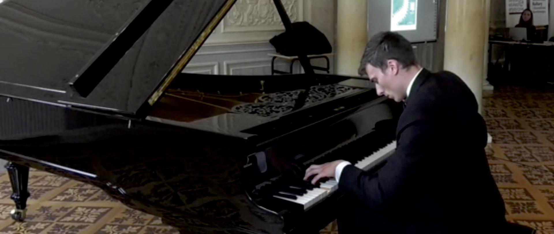 Zdjęcie pianisty Pana Jacka Wendlera wykonującego utwór Chopinowski przy czarnym fortepianie.