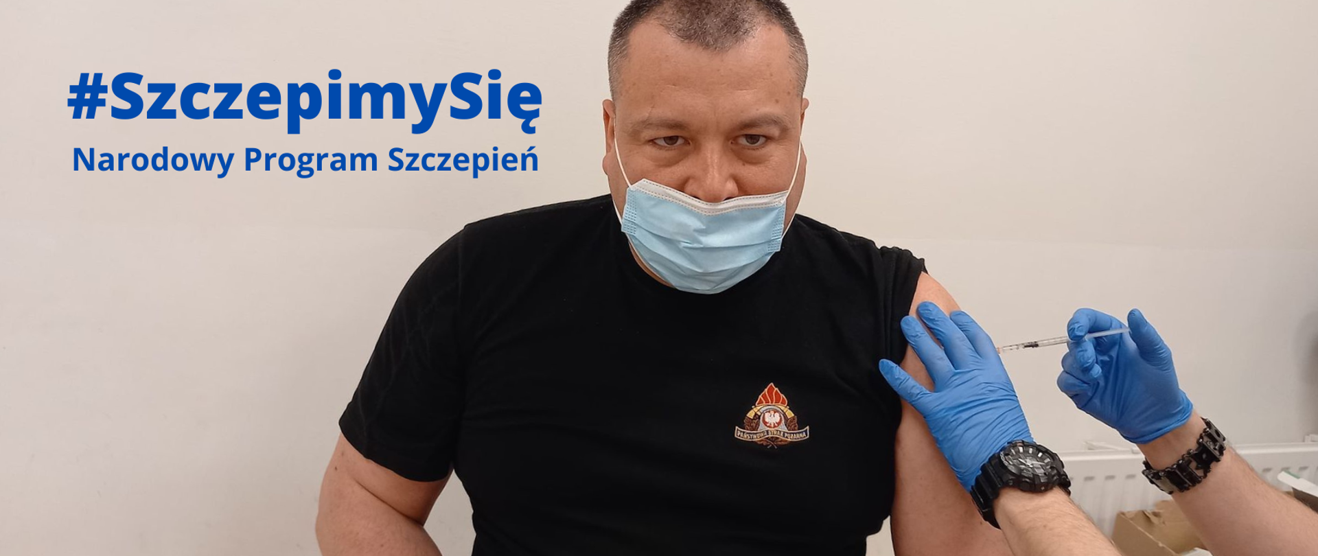 Zdjęcie przedstawia strażaka PSP, który zostaje zaszczepiony.