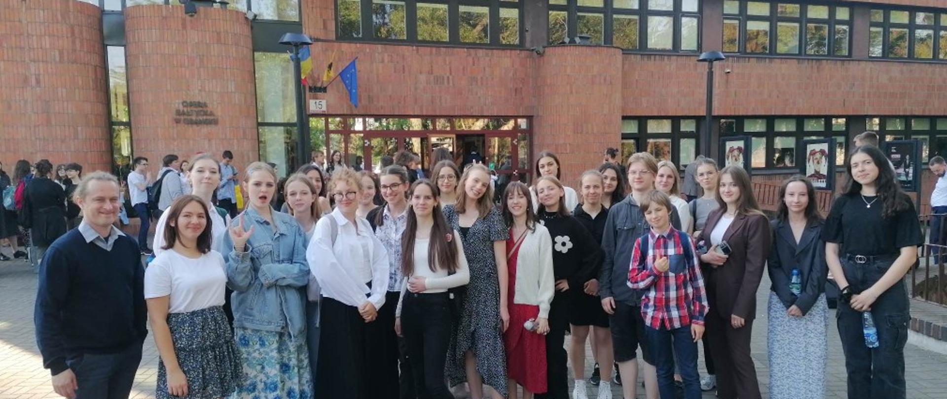 Zdjęcie kolorowe. Grupa uczniów PSM w Słupsku z nauczycielami przed budynkiem Opery Bałtyckiej w Gdańsku.