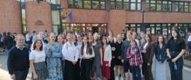 Zdjęcie kolorowe. Grupa uczniów PSM w Słupsku z nauczycielami przed budynkiem Opery Bałtyckiej w Gdańsku.