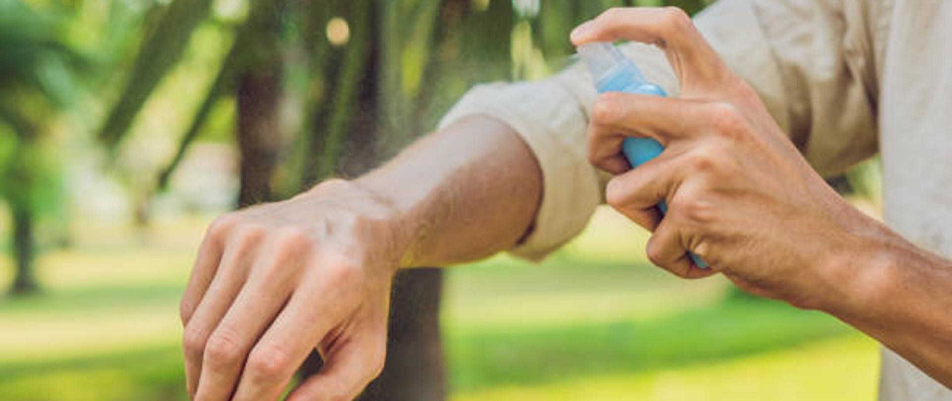 Mężczyzna używa repelentu w sprayu przeciwko owadom