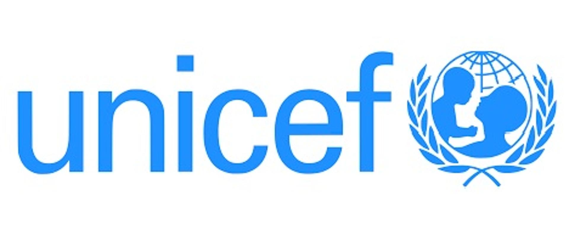 Na obrazku znajduje się niebieski napis na białym tle: unicef. Obok napisu jest kółku zarys matki podnoszącej małe dziecko. Wokoł kółka, również w kolorze niebieskim, są dwa kłosy zboża.