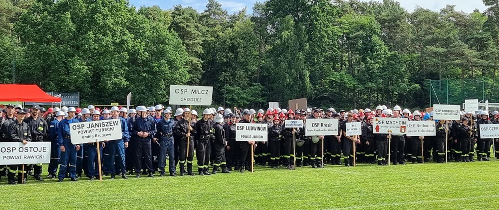 Zdjęcie przedstawia strażaków podczas VII Wojewódzkich Zawodach Sportowo – Pożarnicze Ochotniczych Straży Pożarnych w Wągrowcu.
W tle stadion sportowy.
