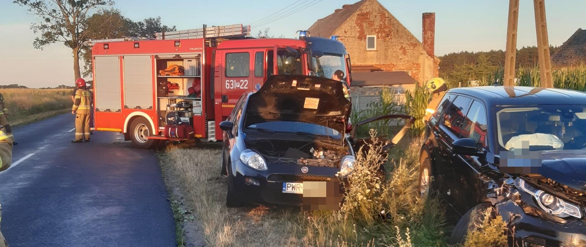 Na zdjęciu widać rozbite pojazdy osobowe, a w tle wóz strażacki 