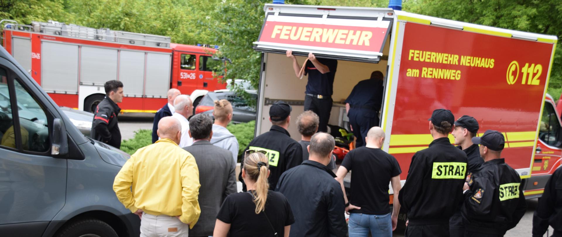 Strażacy i osoby cywilne rozładowują dary dla potrzebujących.