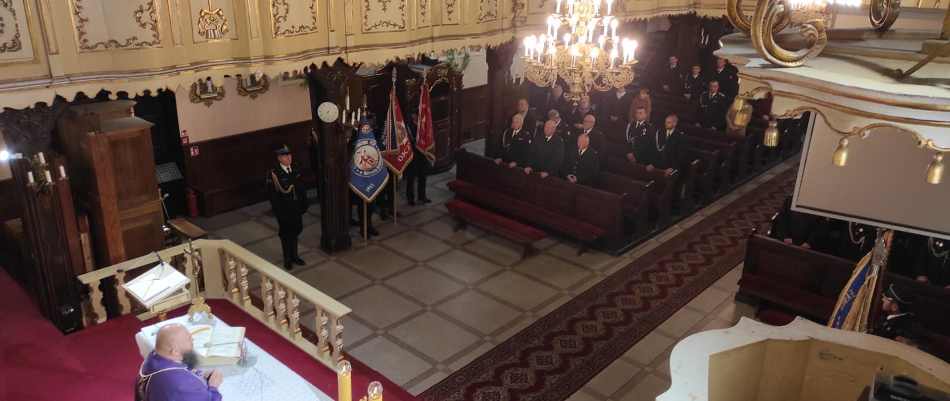 Strażacy uczestniczący w mszy świętej.