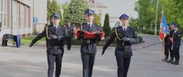 Uroczyste podniesienie Flagi Państwowej z okazji Dnia Flagi Rzeczypospolitej Polskiej. Trzech strażaków - poczet flagowy niosą flagę