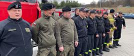 Na zdjęciu widać żołnierzy oraz strażaków podczas rozpoczęcia szkolenia. Funkcjonariusze ubrani w umundurowanie koszarowe. 