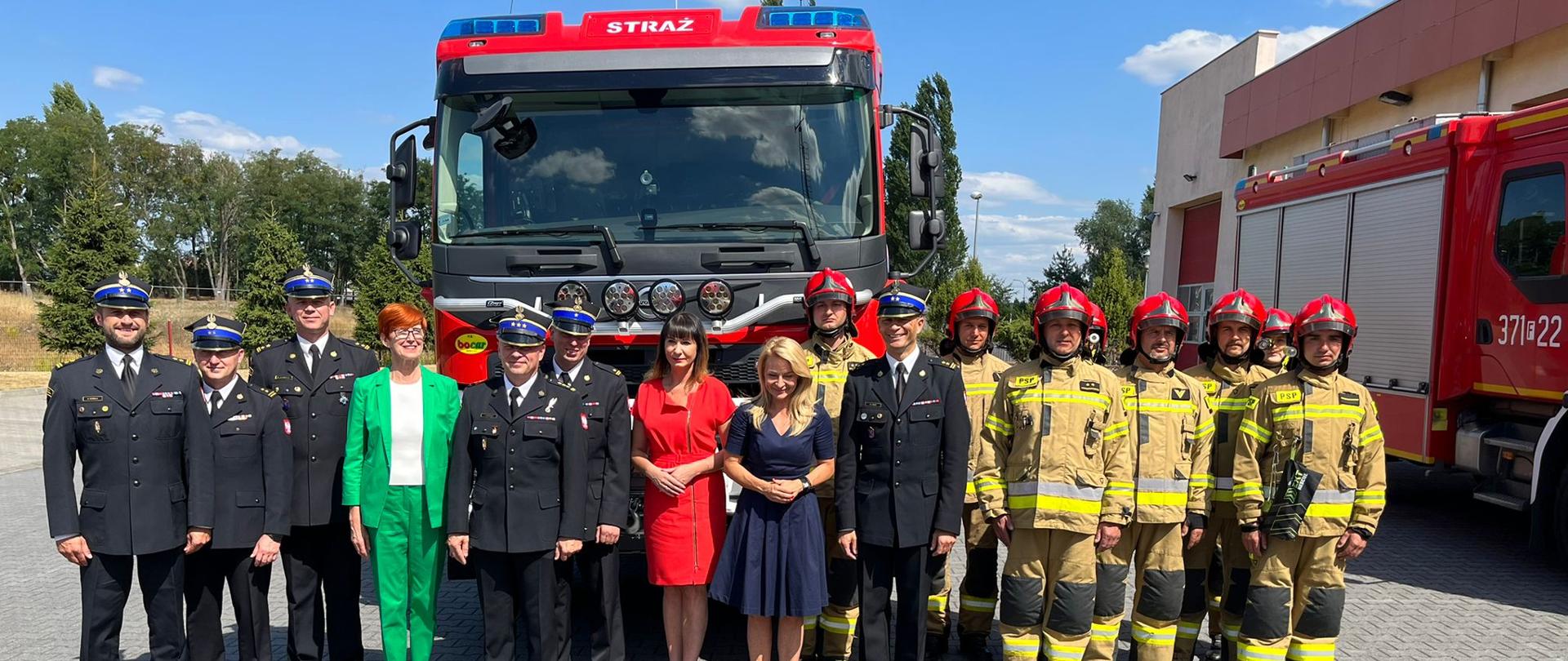 Zdjęcie przedstawia zaproszonych gości oraz strażaków z JRG Międzyrzecz na tle nowego pojazdu gaśniczego marki Volvo.