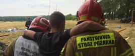 Zdjęcie przedstawia Strażaków PSP udzielających pierwszej pomocy osobie poszkodowanej.