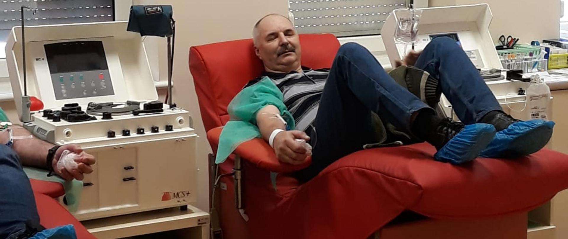 Na zdjęciu widoczny jest strażak na fotelu oddający osocze