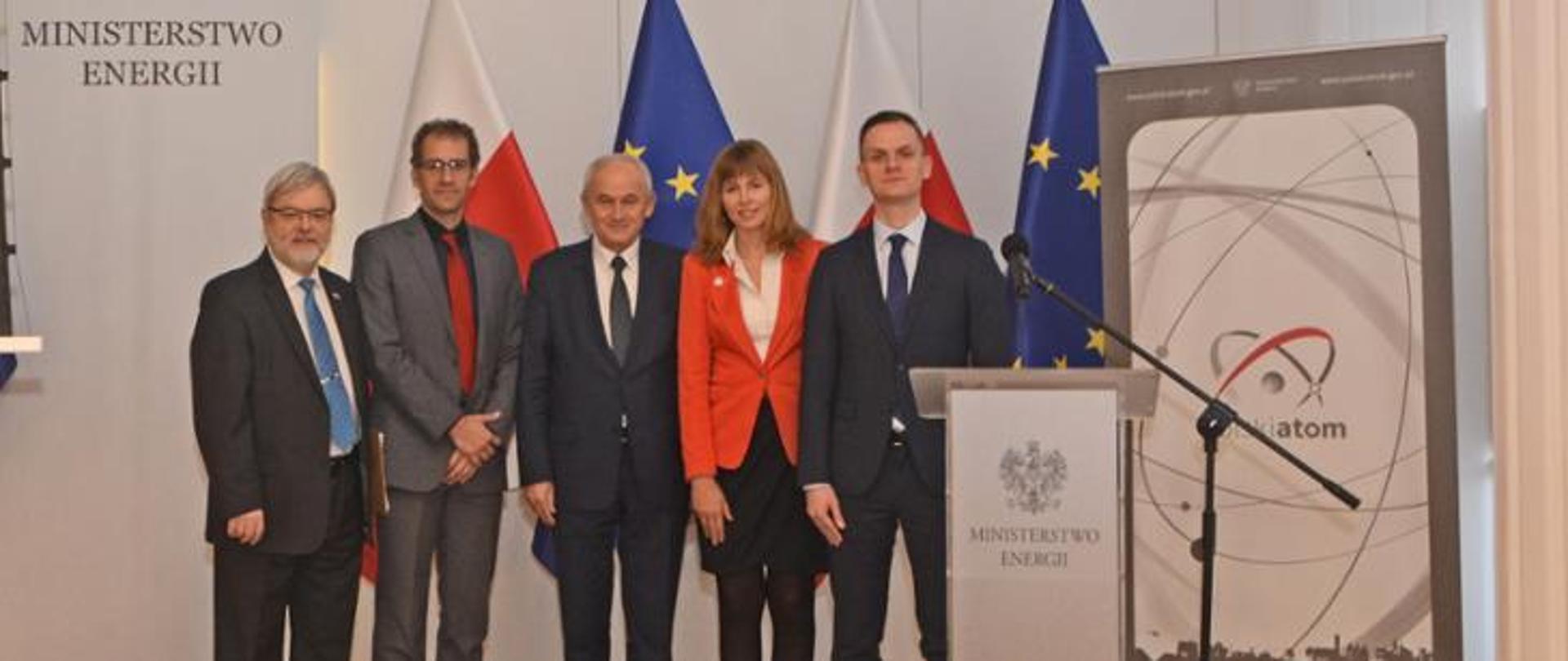 Zdjęcie pięciu osób biorących udział w prezentacji Raportu MIT o przyszłości energetyki jądrowej. Wśród osób obecnych na zdjęciu są między innymi dyrektor Departamentu Energii Jądrowej Józef Sobolewski, profesor Jacopo Buongiorno oraz minister energii Krzysztof Tchórzewski. 