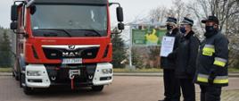Przekazanie samochodu Tychów Stary. NA pierwszym planie widoczny przekazany samochód bojowy oraz druhowie OSP.