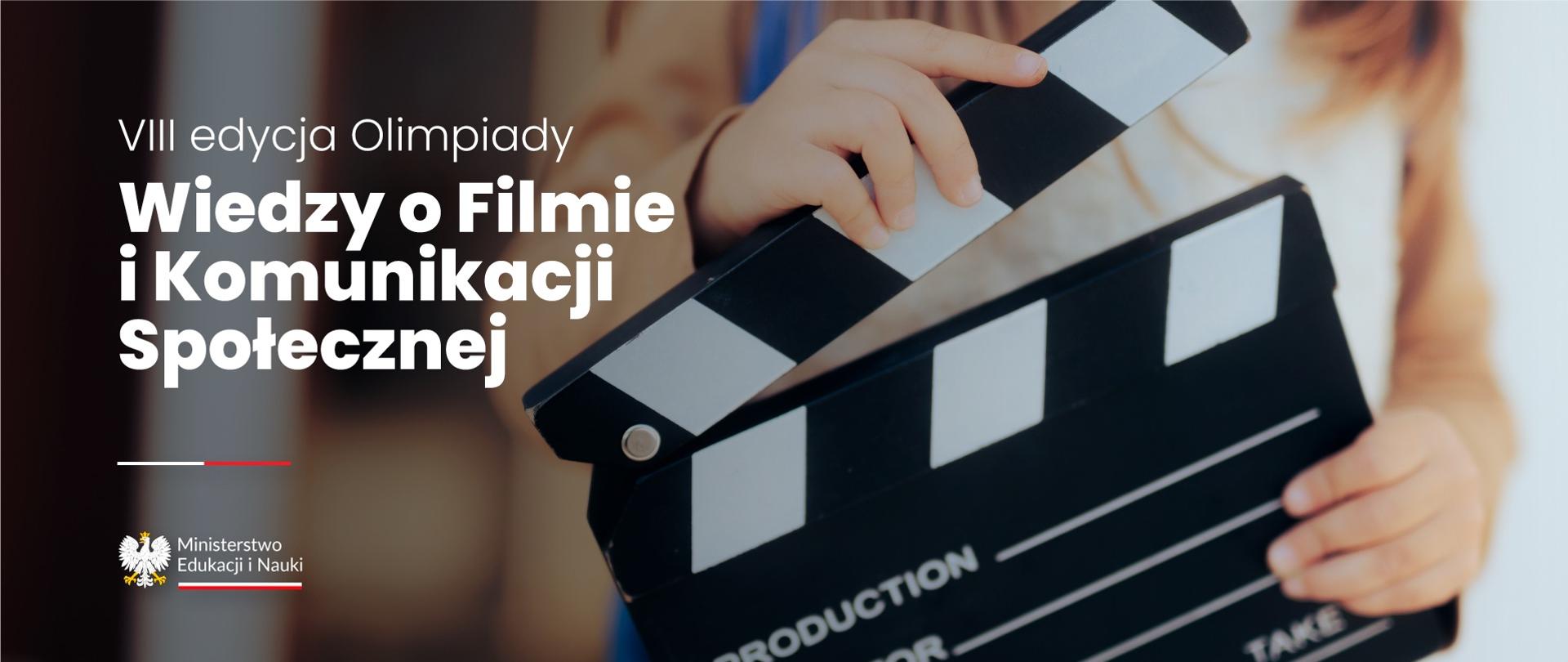 Ręce trzymające filmowy klaps, obok napis VIII edycja Olimpiady Wiedzy o Filmie i Komunikacji Społecznej.