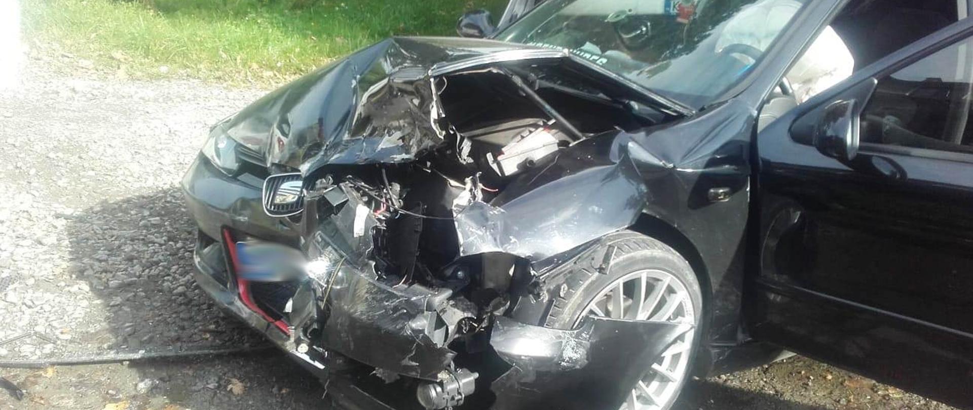 Rozbity samochód osobowy na poboczu.