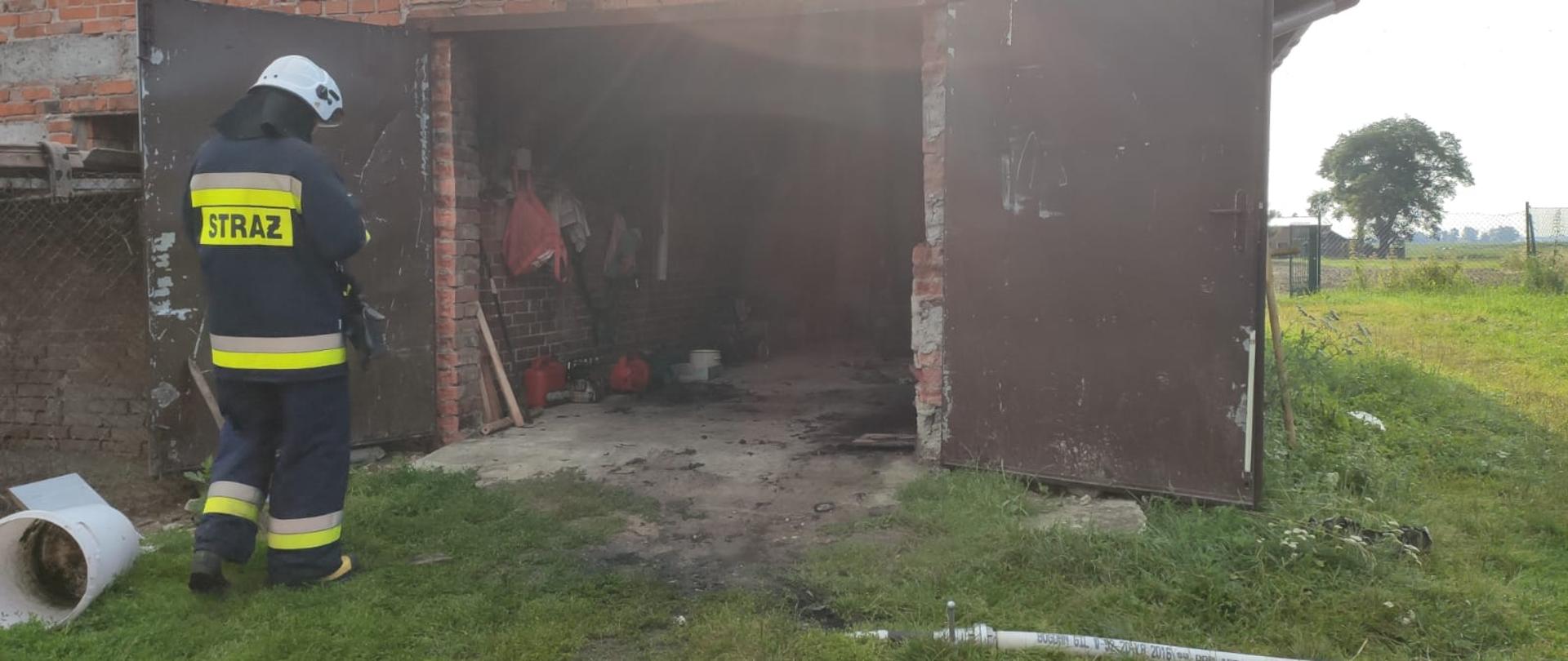 Strażak stojący przed garażem.