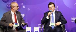 Wiceminister rozwoju i technologii Piotr Uściński podczas dyskusji panelowej "Budownictwo pod presją" na Europejskim Kongresie Gospodarczym w Katowicach, po prawej stronie od wiceministra siedzi dziennikarz ekonomiczny Adrian Ołdak
