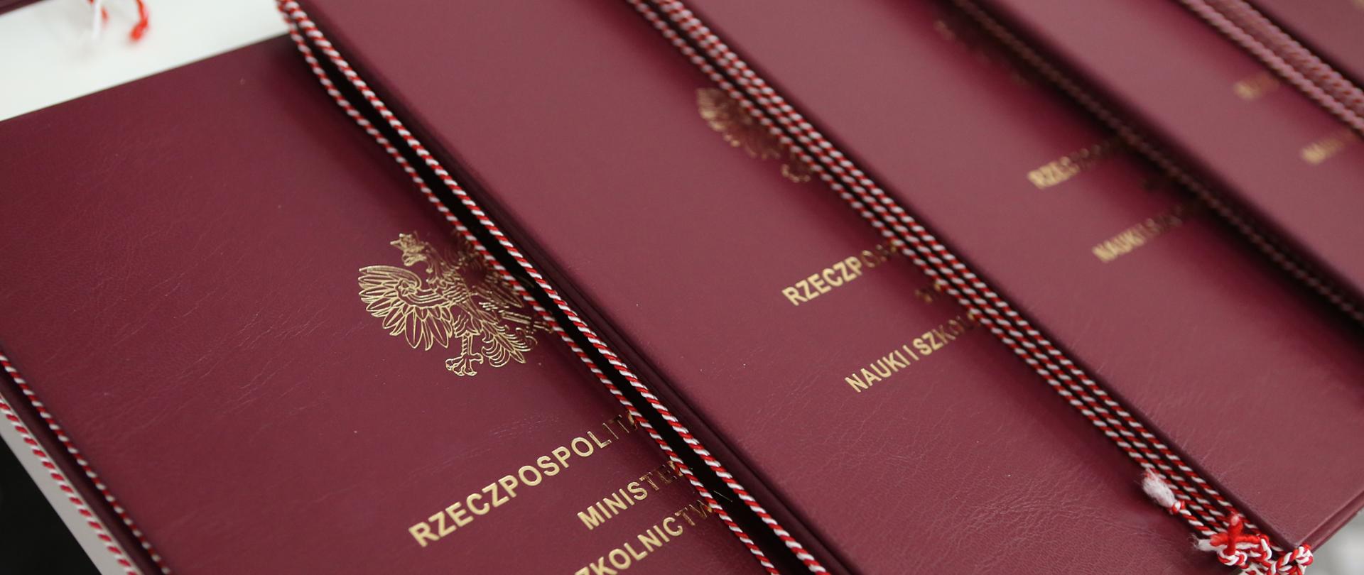 Bordowe teczki z godłem i nazwą ministerstwa