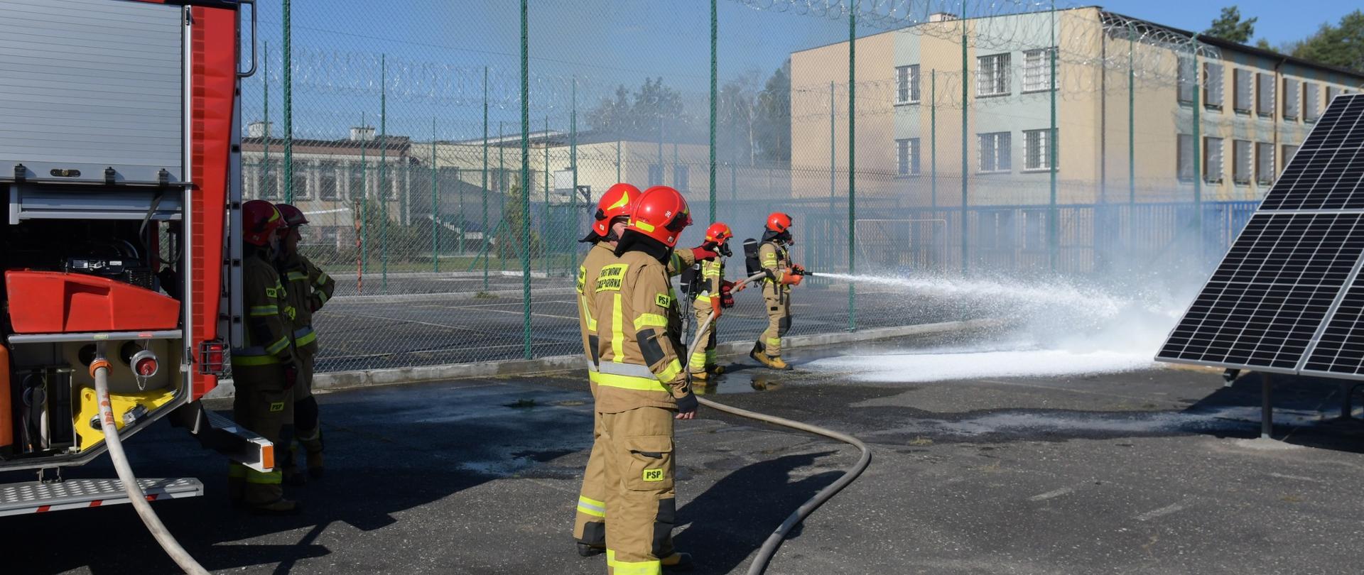 Ćwiczenia na terenie Zakładu Karnego, w tle strażacy z JRG