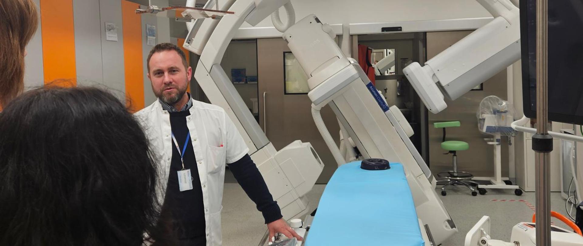 Uśmiechnięty mężczyzna prowadzący szkolenie pokazuje urządzenia medyczne