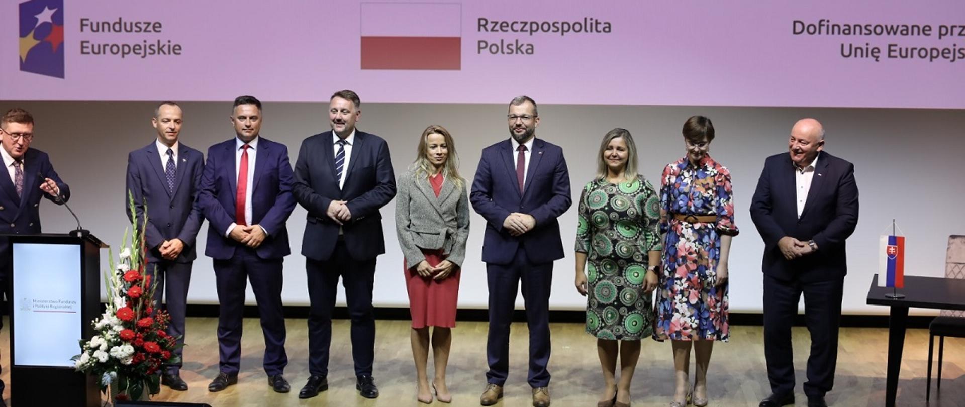 Minister funduszy i polityki regionalnej Grzegorz Puda stoi na scenie wraz z uczestnikami konferencji poświęconej możliwościom pozyskania funduszy europejskich na kulturę, po jego lewej stronie Dyrektor Generalna z Sekcji Programów Współpracy Transgranicznej Lea Mala z Ministerstwa Inwestycji, Rozwoju Regionalnego i Informatyzacji Republiki Słowackiej 