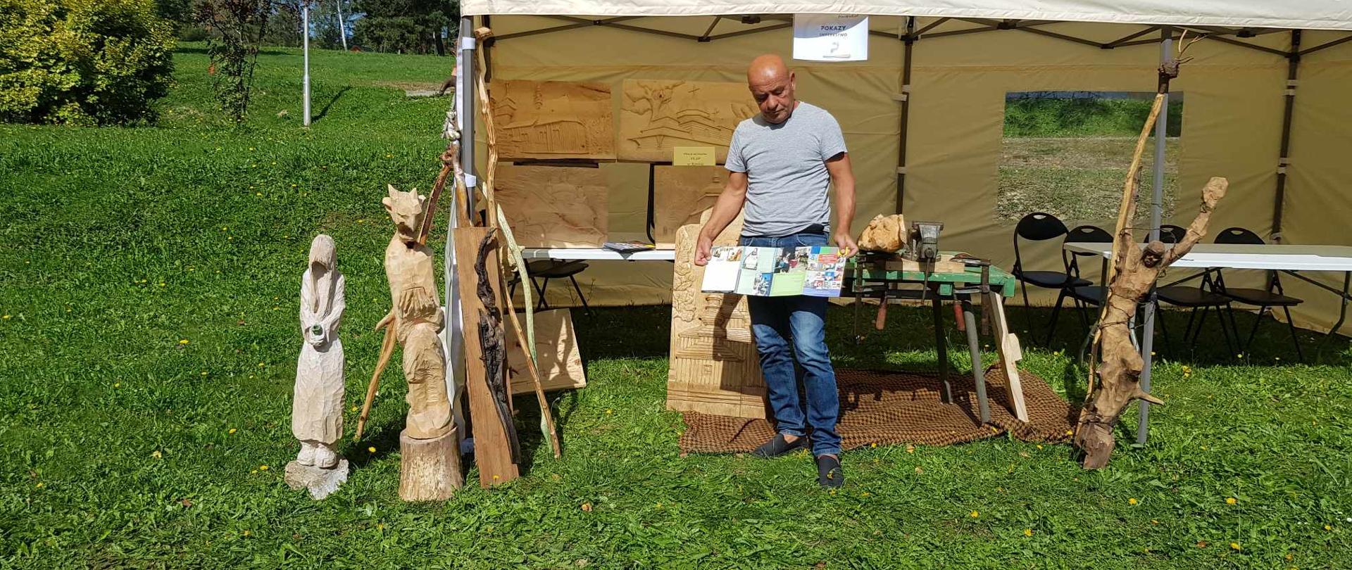 Cartpathia EtnoWeekend w Polańczyku - na zdjęciu artysta wraz z rzeźbami z drewna