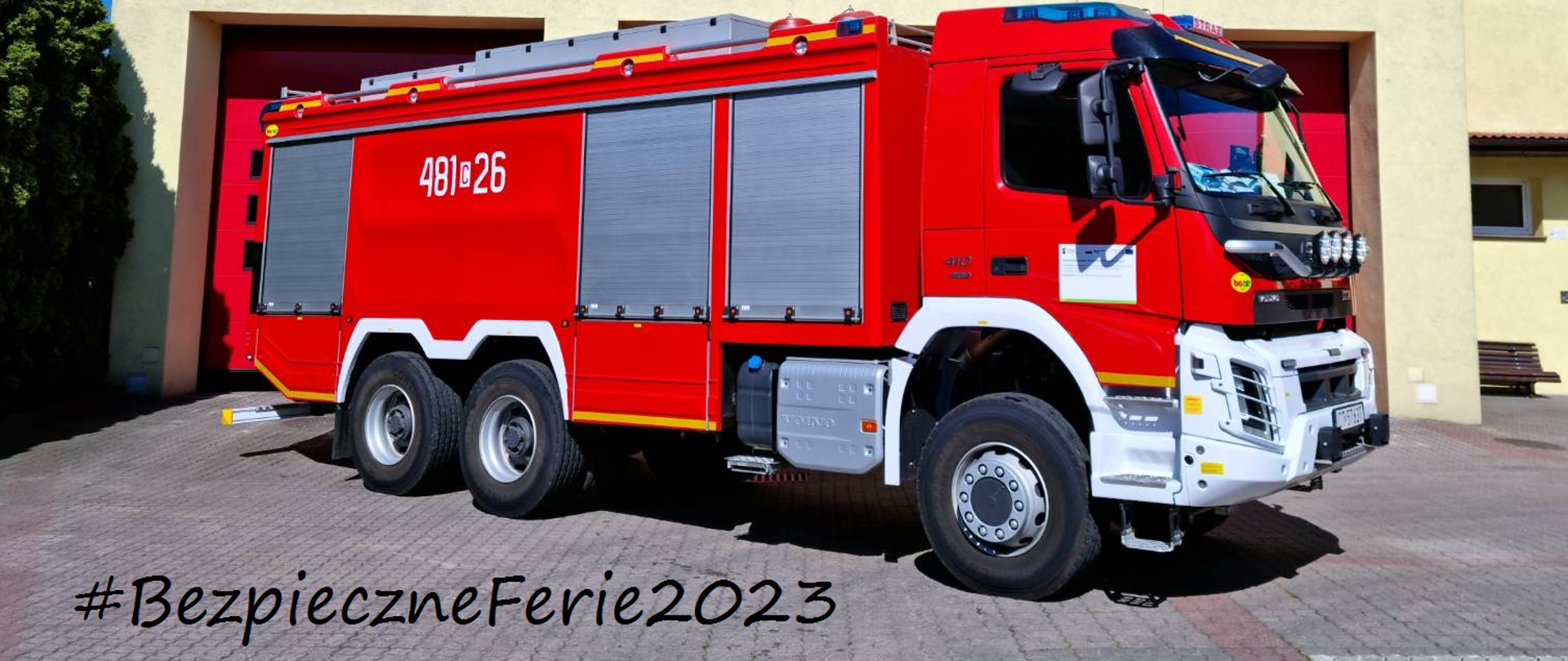 Samochód pożarniczy przed budynkiem komendy