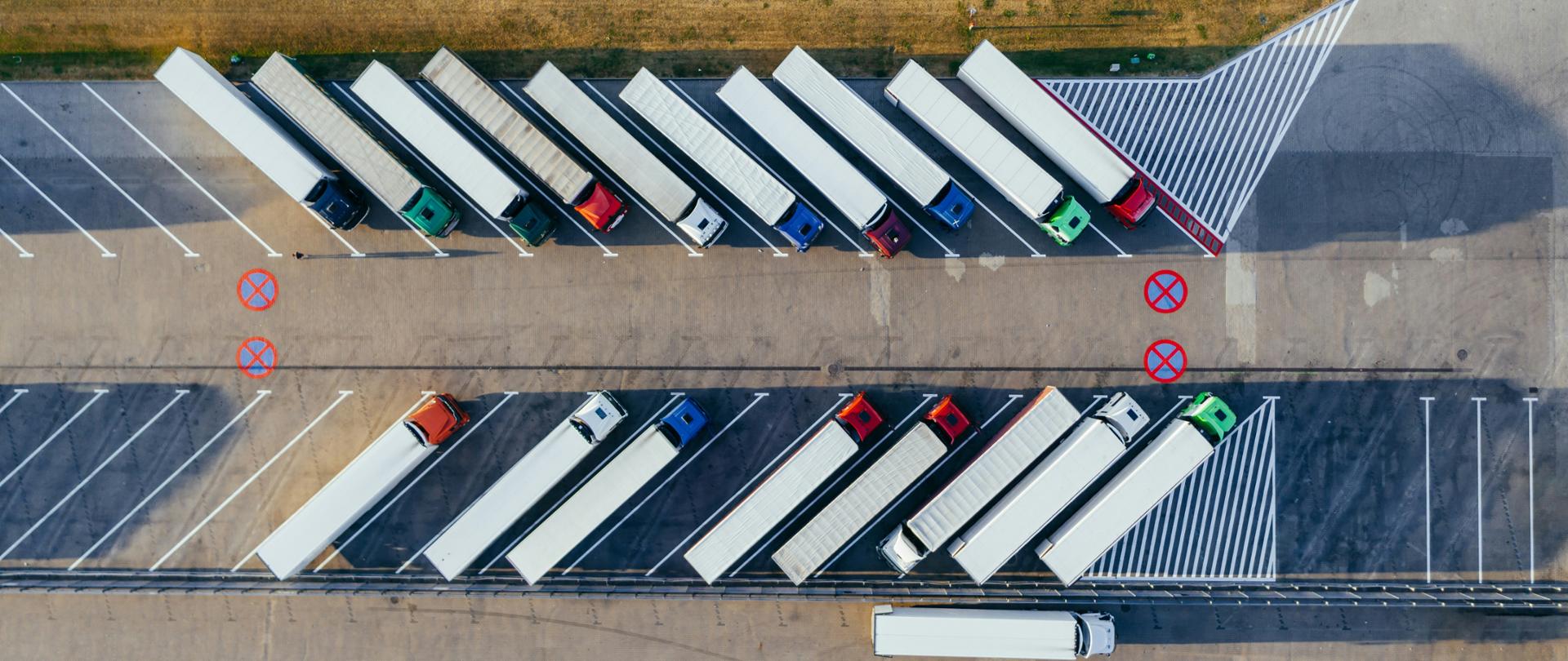 Kilkanaście ciężarówek stoi na parkingu