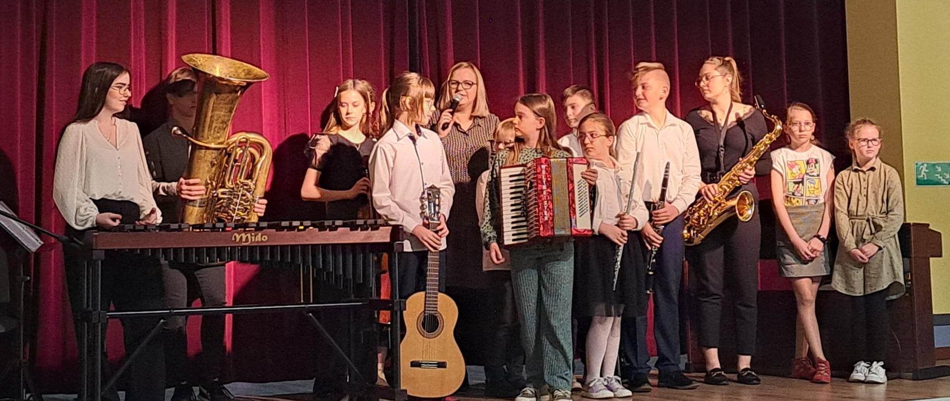 uczniowie z instrumentami zebrani na scenie