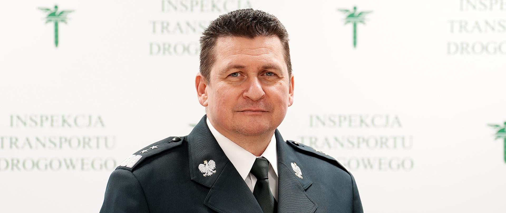 Mężczyzna w inspekcyjnym mundurze - Główny Inspektor Transportu Drogowego - na tle ścianki z napisem Inspekcja Transportu Drogowego i logo ITD