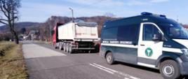 Zespół pojazdów zatrzymany na jednej z krakowskich ulic przez inspektorów małopolskiej ITD. Na pierwszym planie inspekcyjny furgon. Za nim ciężarówka. W tle droga wojewódzka i okoliczne zabudowania.