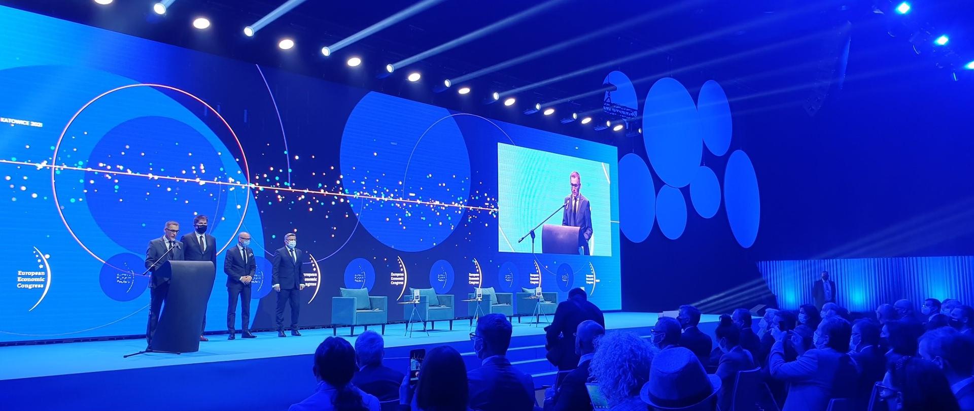 Uroczysta inauguracja, widok na scenę i widownię. Za panelistami ekran plansza z logo i napisem: Europejskiego Kongresu Gospodarczego