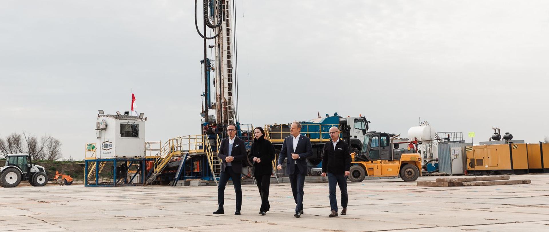 Premier Donald Tusk, prezes Zarządu KGHM Andrzej Szydło, minister Wojciech Balczun i wiceminister Eliza Zeidler. W tle plac budowy. 