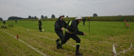 Strażacy OSP w trakcie biegu w konkurencji 7x50m z przeszkodami Gminnych zawodów Sportowo-Pożarniczych w Holonkach.