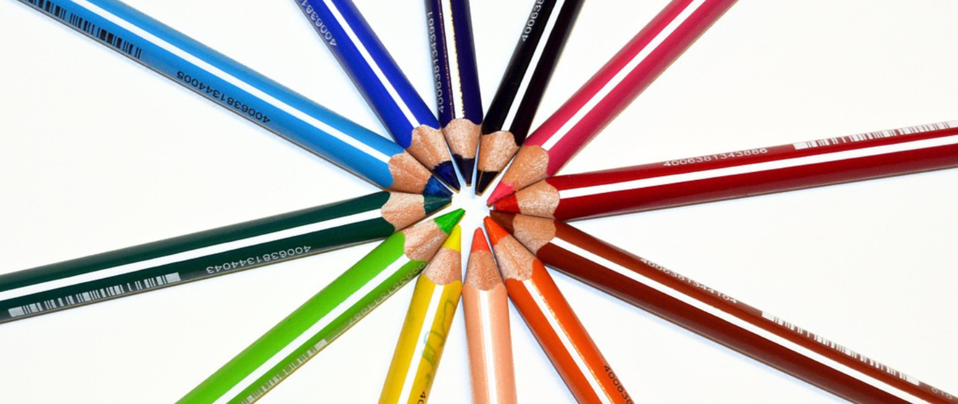 Grafika przedstawia kolorowe kredki tworzące krąg na białym tle.