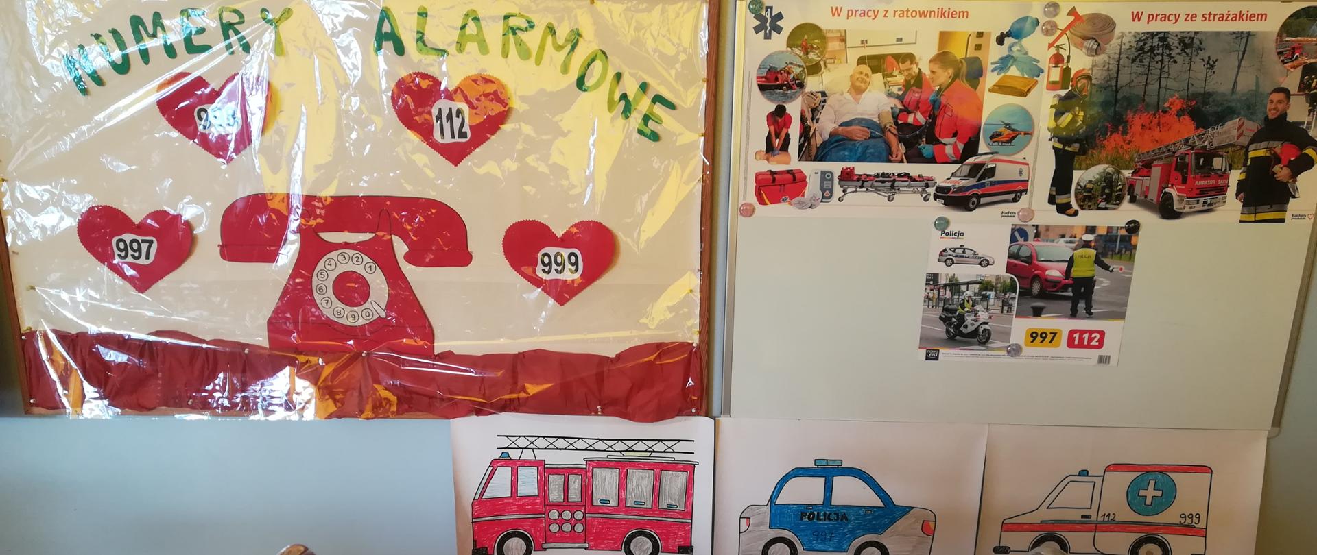 na stole stoi tort w kształcie serca z numerem 112. w tle widoczne zdjecia samochodów słuzb ratowniczych