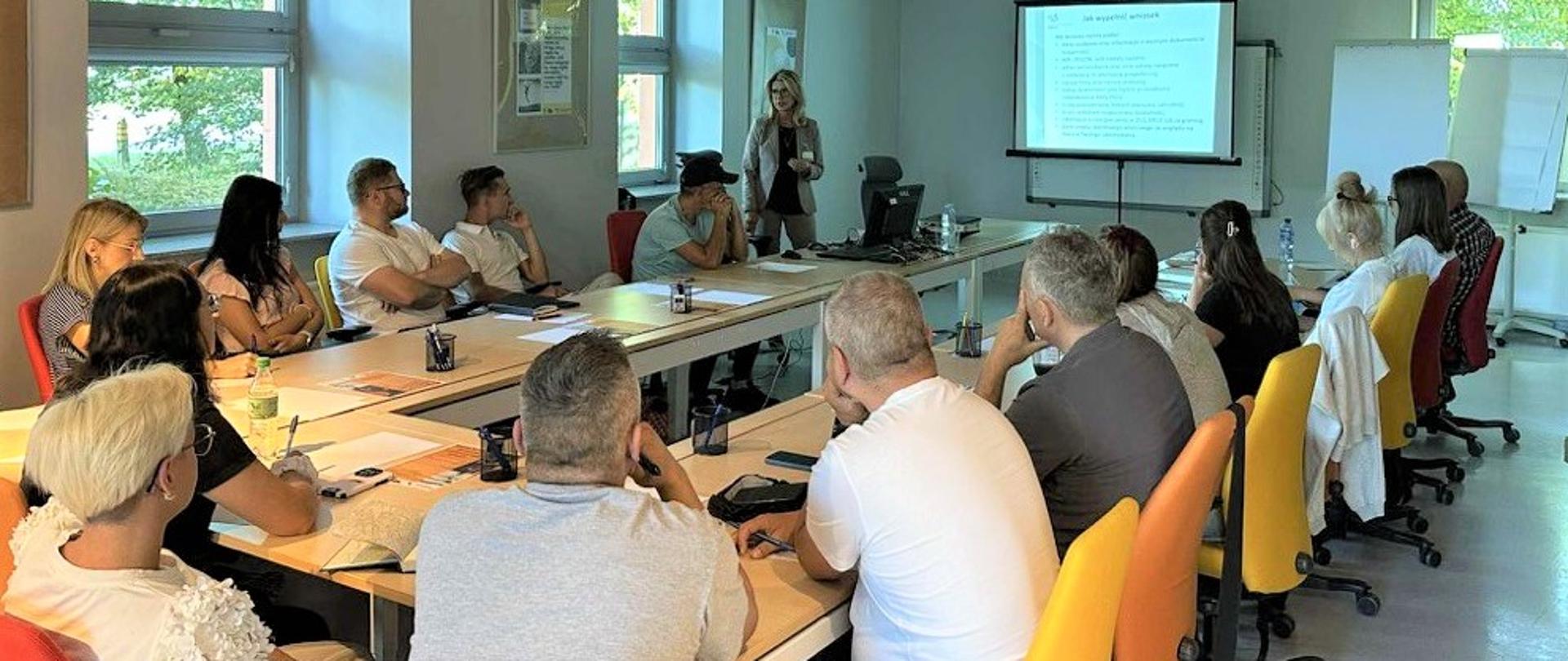 Grupa ludzi przy stole w sali szkoleniowej 