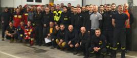 Grupa strażaków pozuje do zdjęcia.