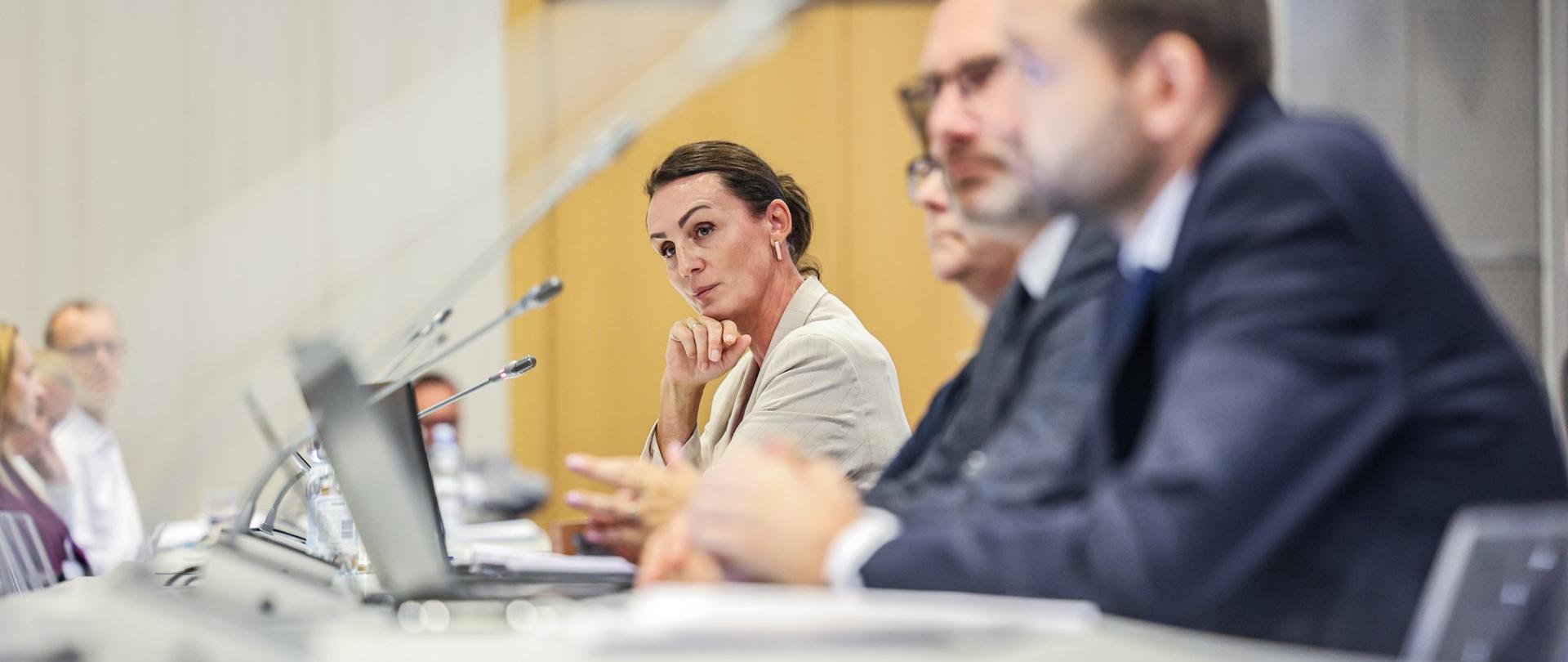 kobieta siedzi w sali i słucha przemówienia