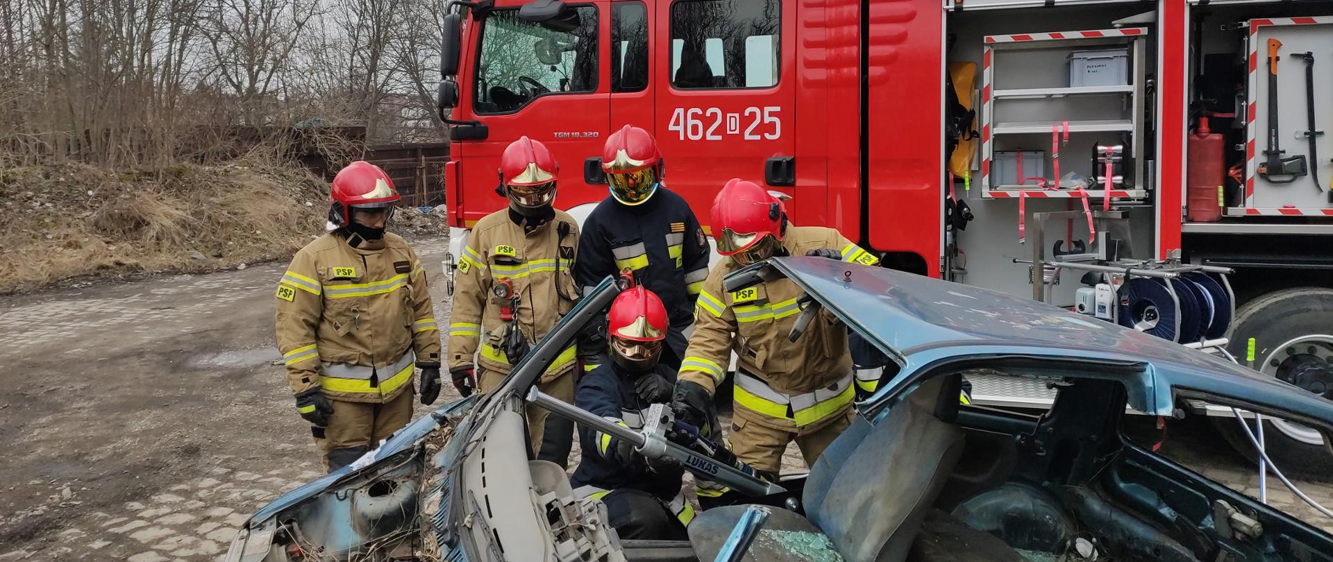 Na zdjęciu strażacy przy wraku samochodu