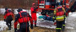 Na zdjęciu strażacy ćwiczą na zalodzonym zbiorniku wodnym