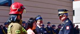 Przedstawiciele strażaków oraz pracownik cywilni wręczają kwiaty pomorskiemu komendantowi wojewódzkiemu Państwowej Straży Pożarnej.