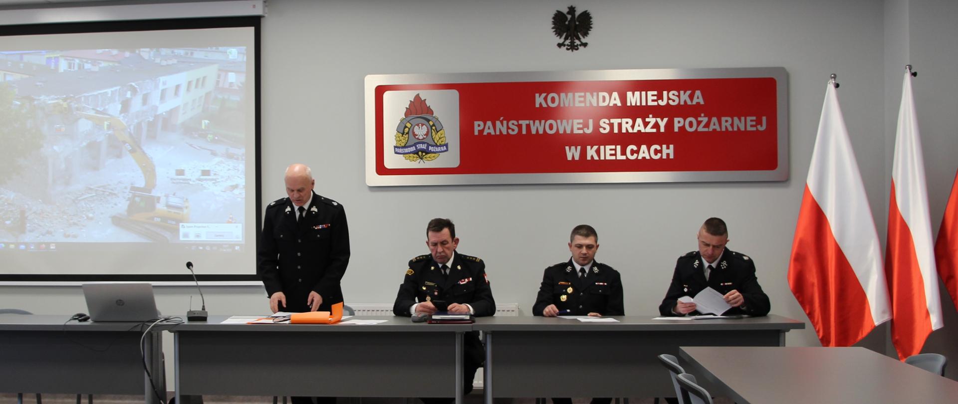 Zdjęcie przedstawia salę konferencyjną. Za stołem znajdują się od lewej: dh Ireneusz Żak, st. bryg. Sławomir Karwat, dh Piotr Biegański, dh Michał Jarząb